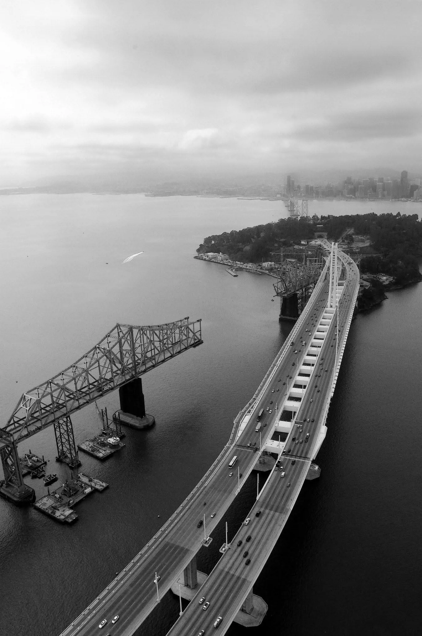Black-and-white aerial photograph of the old and new Bay Bridge spans
